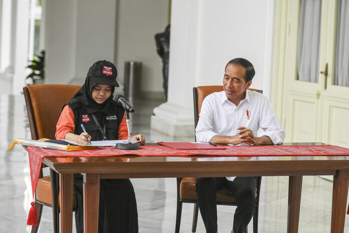 Presiden Joko Widodo (kanan) menyaksikan petugas pemutakhiran data pemilih (Pantarlih) mencocokan dokumen kependudukannya saat proses pencocokan dan penelitian (Coklit) data pemilih untuk Pemilu 2024 di Istana Merdeka, Jakarta, Selasa (14/2/2023).